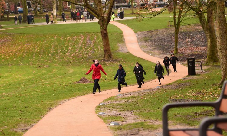 Kids and teacher running through Winckley Square in Preston