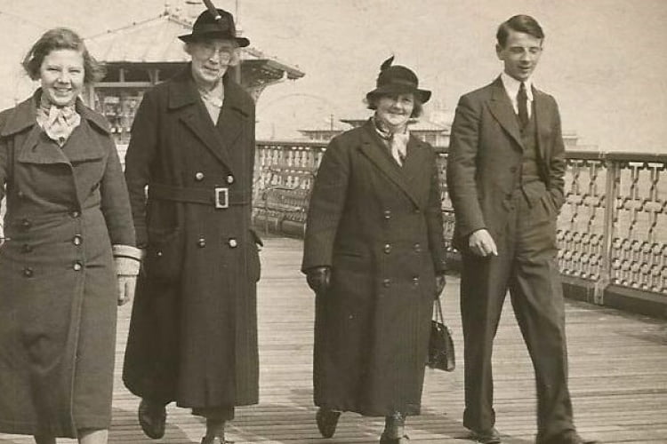 Black and white photograph of 4 people walking